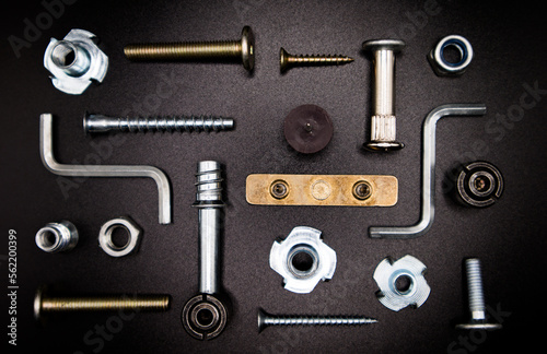 Furniture fittings. Furniture assembly hardware options and tools on a black background. Large selection of furniture accessories.
