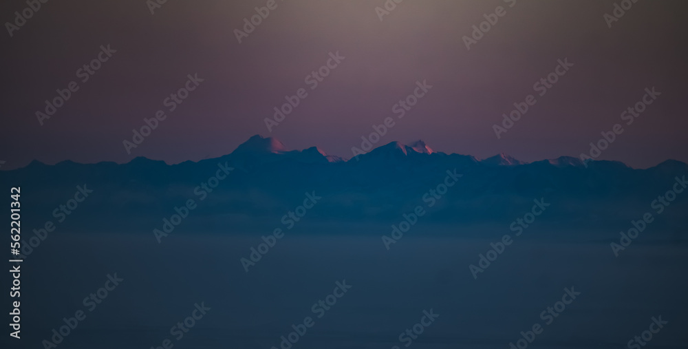 Panorama of the mountain range of the Caucasus Mountains at sunset, view of the mountain peaks in winter in the evening at sunset Panorama of the mountain range of the Caucasus Mountains at sunset, view of the mountain peaks in winter in the evening at sunset
