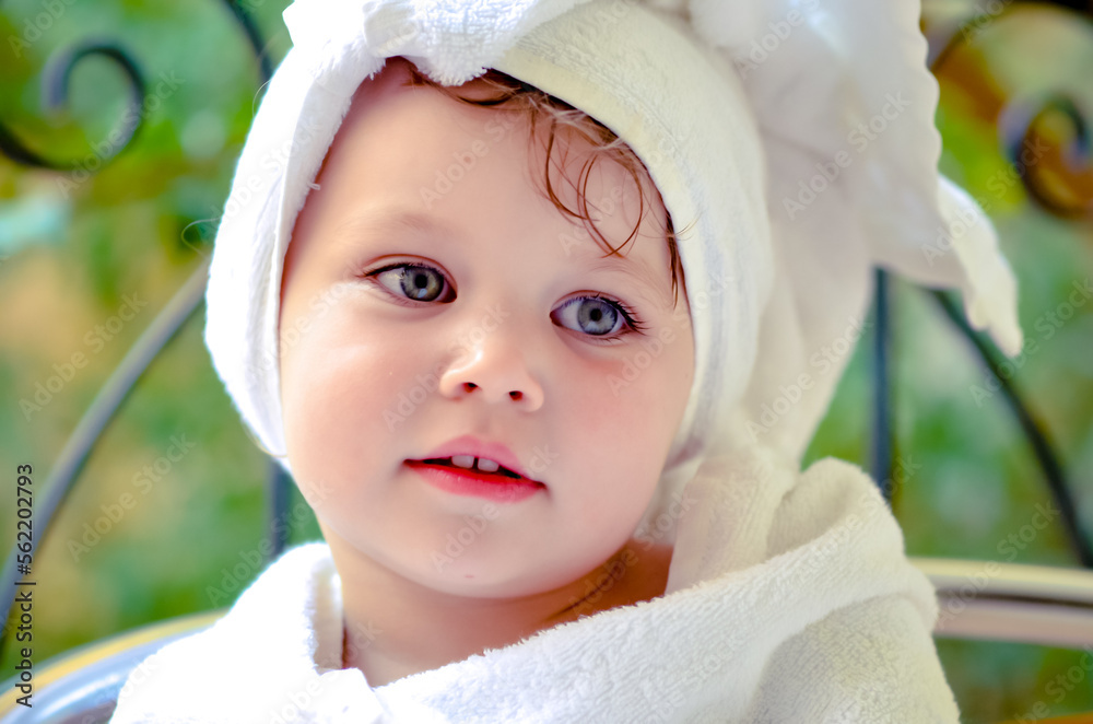 Cute portrait of a young girl getting out of the bath and waiting in the garden Cute portrait of a young girl getting out of the bath and waiting in the garden