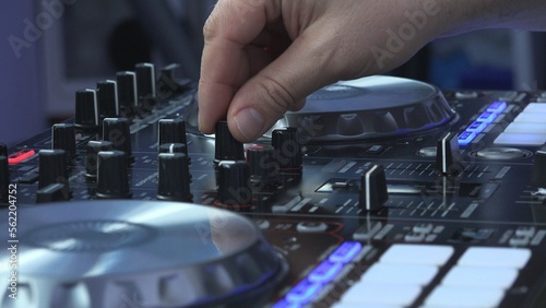 DJ hands mixing music on turntable, detail lateral view