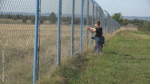 Children want to climb a big fence, brother panning adventure to escape