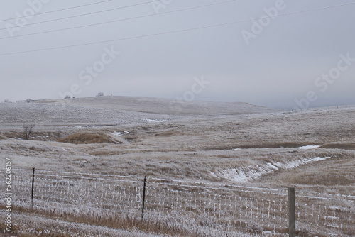 Frozen fence and grassland on a cold, foggy gray day in Gillette, Wyoming. photo