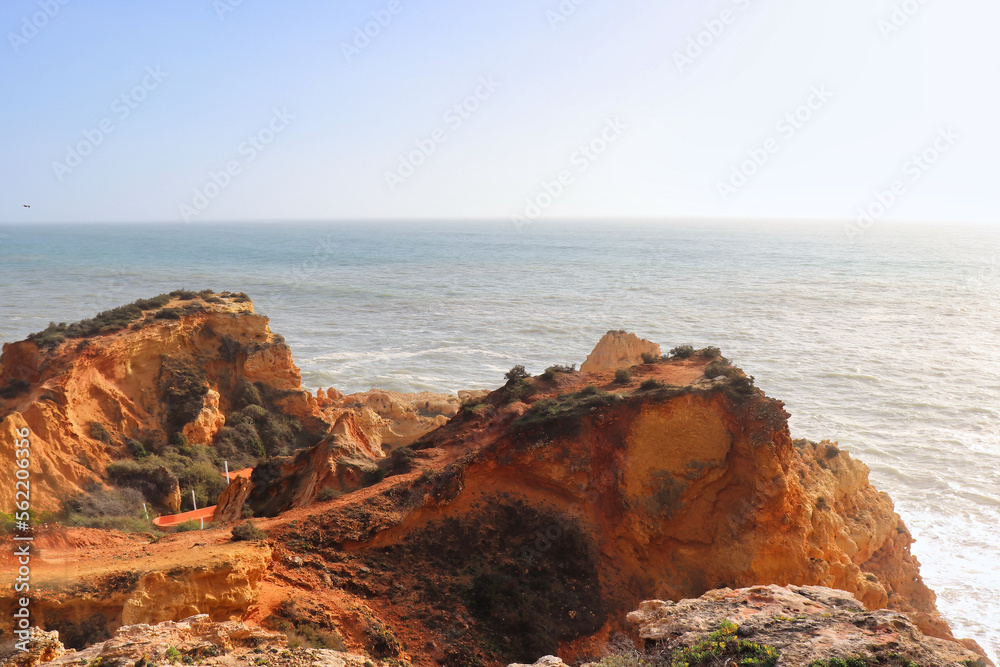 Orange rocks Carvoeiro, Portugal next to the Atlantic Ocean on a warm, sunny winter day.