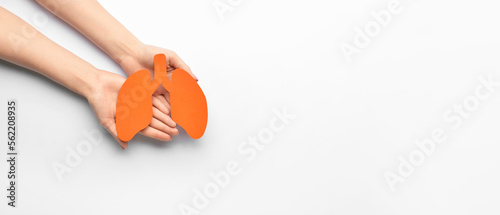 Female hands holding paper lungs on white background with space for text photo