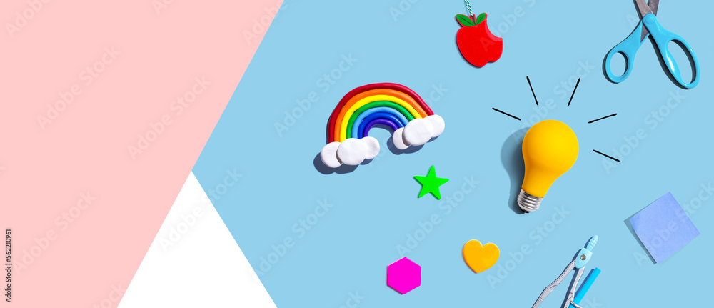 Idea light bulb with a rainbow and school supplies - flat lay Idea light bulb with a rainbow and school supplies - flat lay