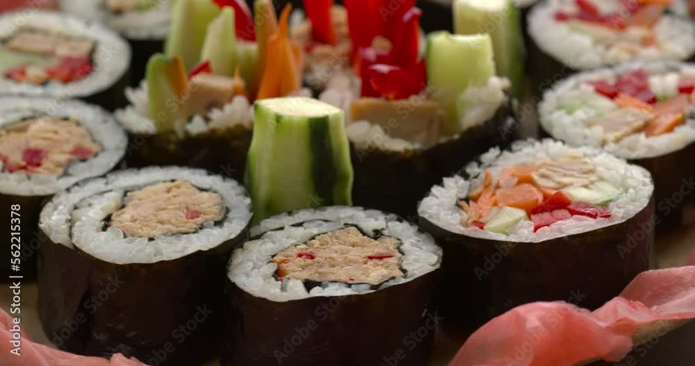 Homemade futomaki maki sushi rolls with vegetables and canned tuna fish close-up view. Table spin. Homemade futomaki maki sushi rolls with vegetables and canned tuna fish close-up view. Table spin.