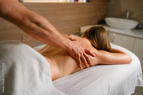 Young woman lies on a couch and relaxes from a pleasant back massage at spa