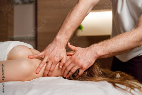 Woman receiving neck massage in spa salon
