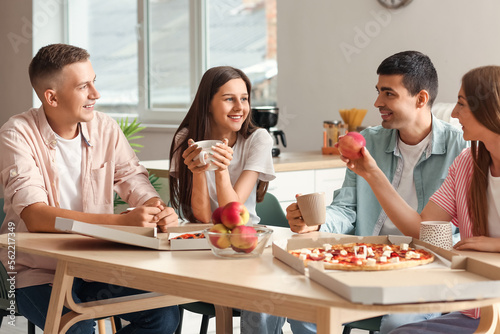 Group of friends spending time together at table in kitchen