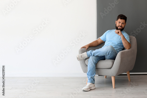 Handsome man sitting in arm...