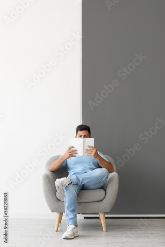 Handsome man reading book i...