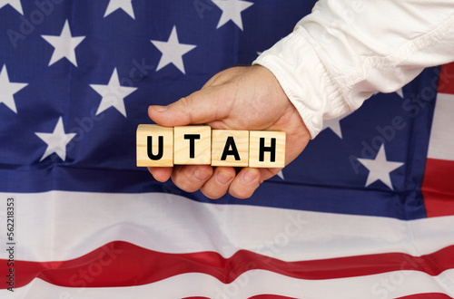 Against the background of the USA flag, a man's hand with cubes with the text - UTAH