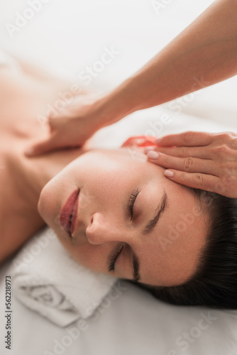 Young woman lying on bed, having massage