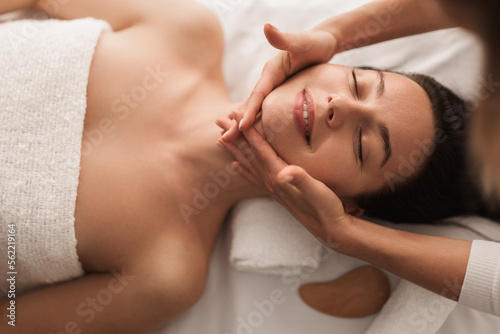 Crop anonymous woman doing facial procedure to smiling female client