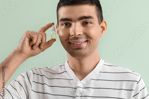 Young man with eye drops on...