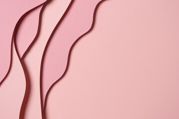 Abstract colored paper texture background. Minimal paper cut composition with layers of geometric shapes and lines in pastel pink colors. Top view, copy space