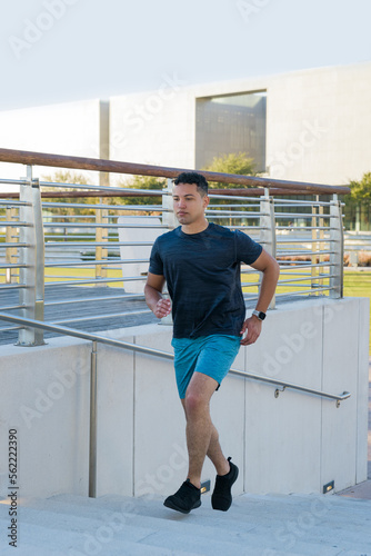 Young man running upstairs outdoor in the city park, healthy lifestyle concept