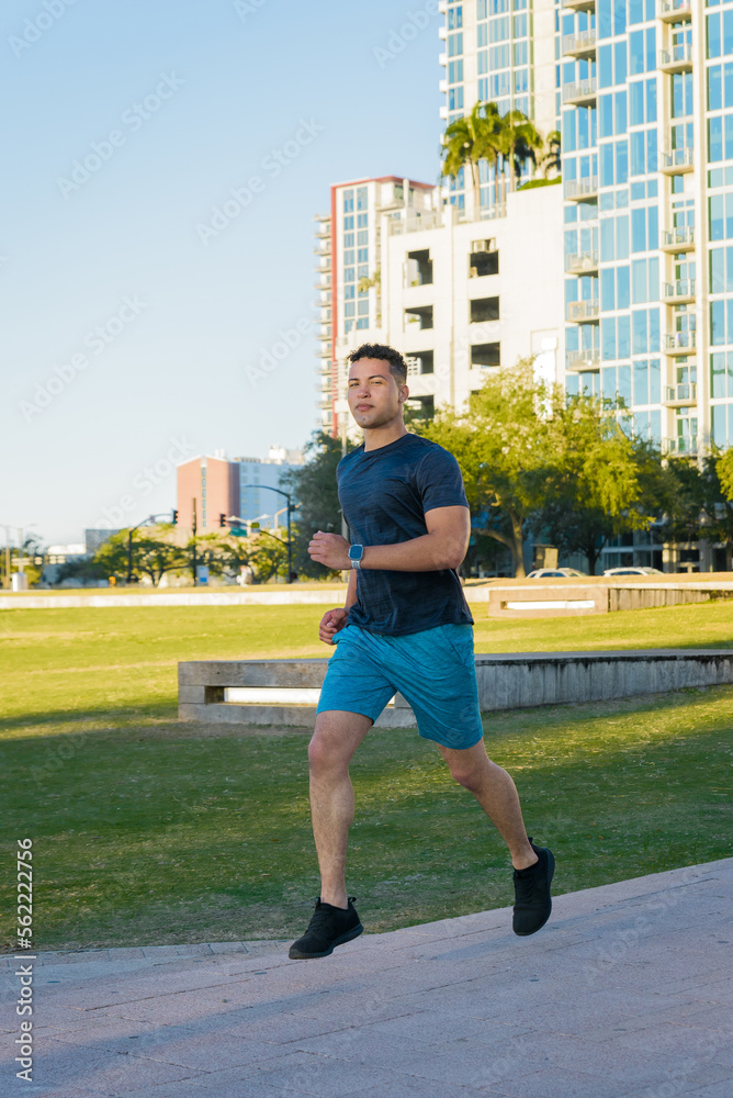 Young man jogging outdoor in the city park, healthy lifestyle concept
