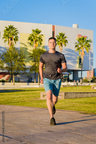 Young man jogging outdoor in the city park, healthy lifestyle concept