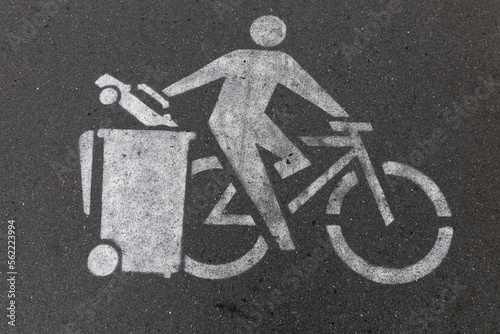 pictogram on asphalt, biker dump a car in trash, litter box as a concept for car free cites, taken on veloroute 10 in german city Kiel photo