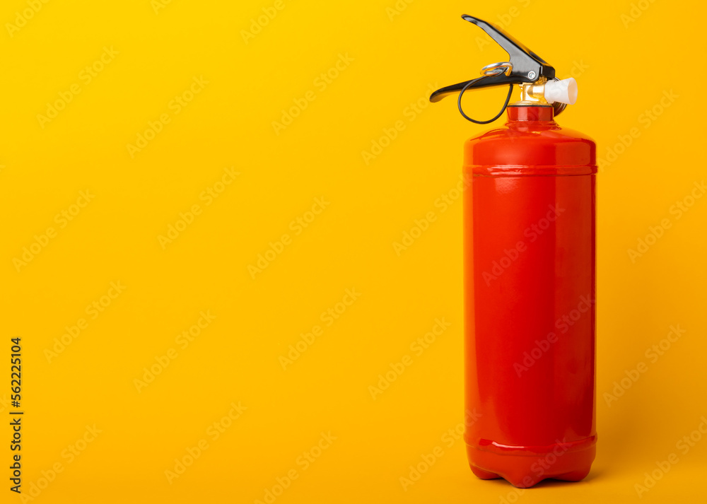 Fire extinguisher on a yellow background. Fire protection, home fire extinguisher. home security concept. Place for text. Copy space.