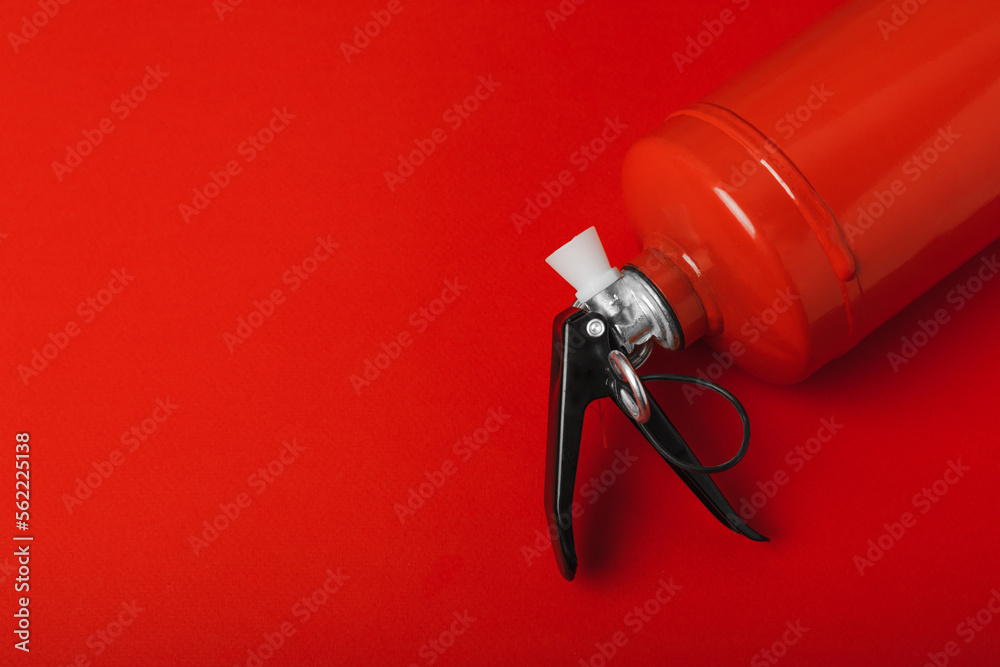 Fire extinguisher on the background of a red wall. Fire protection, home fire extinguisher. home security concept. Place for text. Copy space.