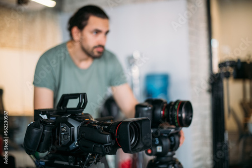 Director of photography with a camera in his hands on the set. Filming process indoors, studio © Anna