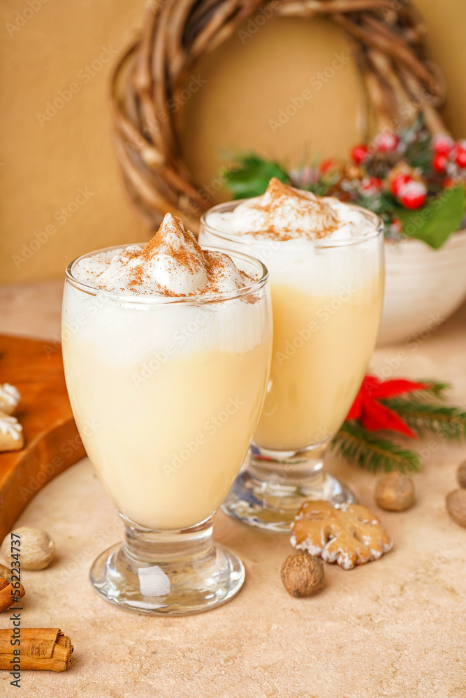 Glasses of tasty eggnog cocktail and Christmas decor on color background Glasses of tasty eggnog cocktail and Christmas decor on color background