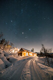Milky Way stars under Cabin House in Norway. Christmas Night with Snow House Hytte