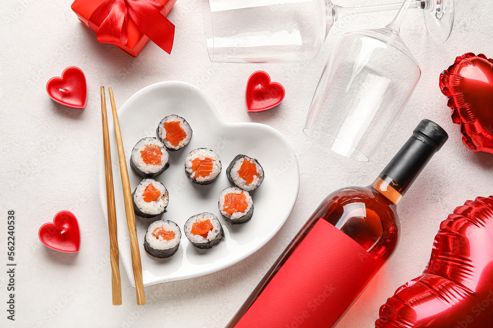 Plate with sushi rolls, chopsticks, candles, wine and gift on white background. Valentine's Day celebration Plate with sushi rolls, chopsticks, candles, wine and gift on white background. Valentine's Day celebration