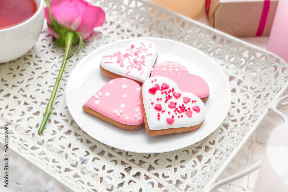 Tray with plate of tasty heart shaped cookies and rose flower on table, closeup. Valentine's Day celebration Tray with plate of tasty heart shaped cookies and rose flower on table, closeup. Valentine's Day celebration