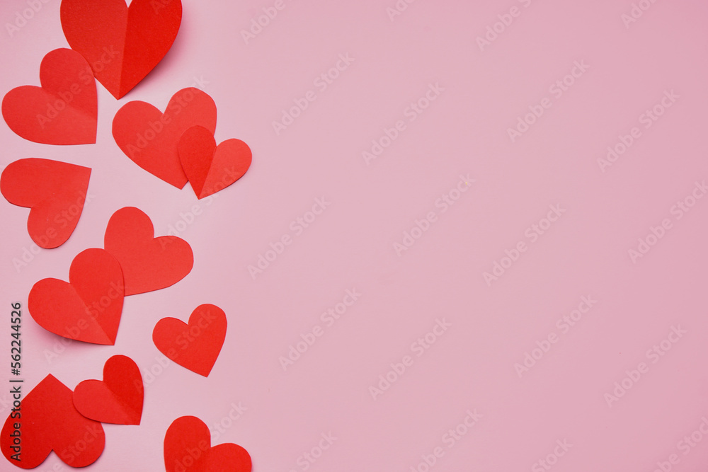Red paper hearts on pink background. Valentines Day celebration