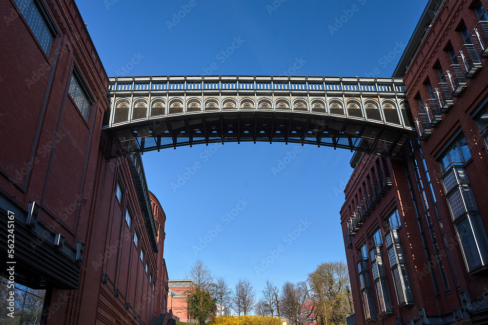 Naklejka premium A metal bridge and a brick walls of a historic brewery