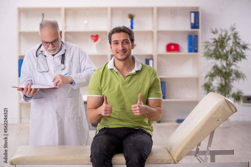 Obraz premium Young male patient visiting old male doctor