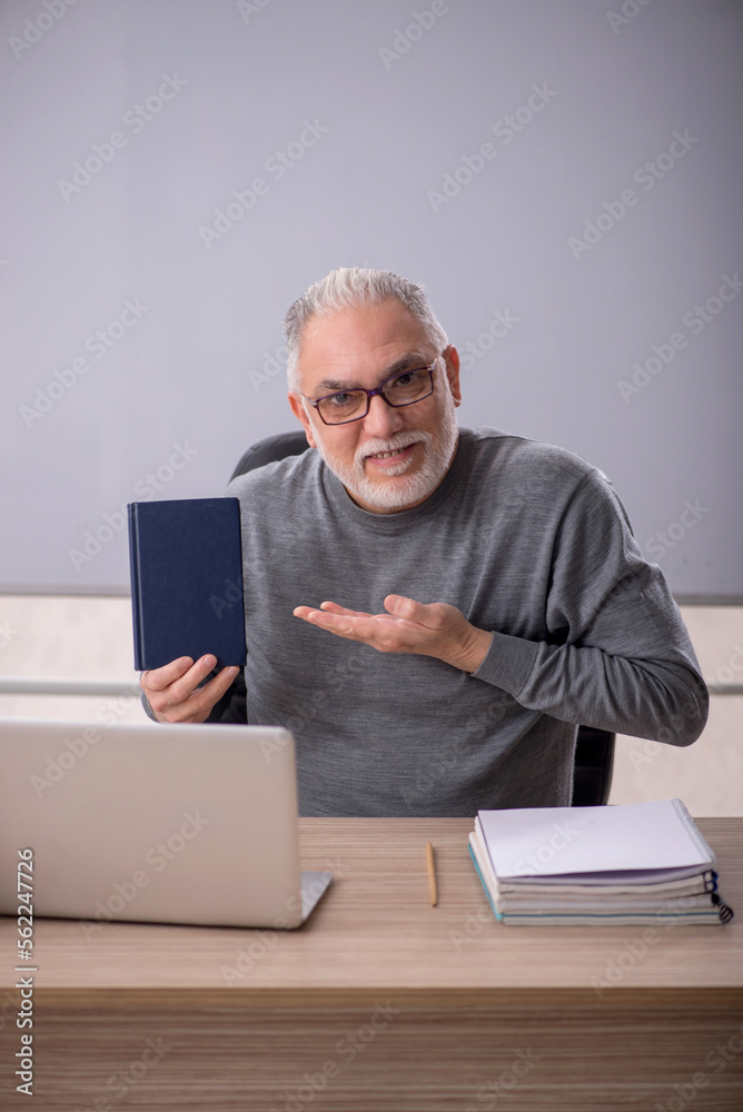 Old male teacher in the classroom Old male teacher in the classroom