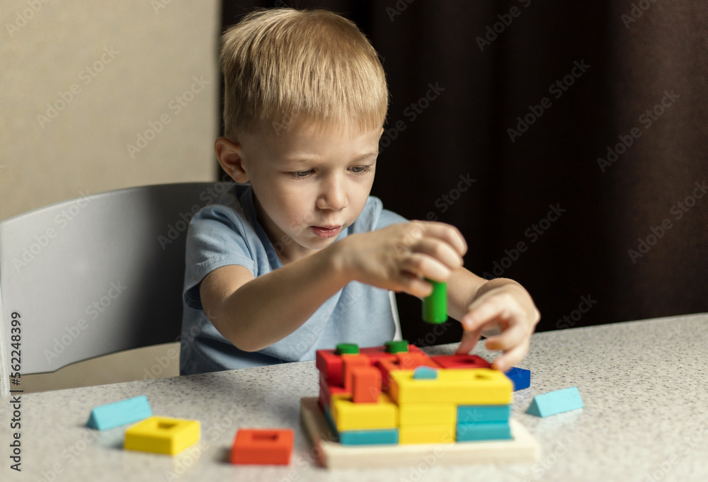 A child plays an educational puzzle toy made of environmentally friendly wood material A child plays an educational puzzle toy made of environmentally friendly wood material