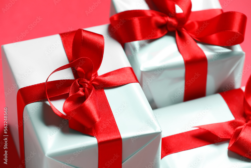 Gift boxes with beautiful bows on red background. Valentine's Day celebration