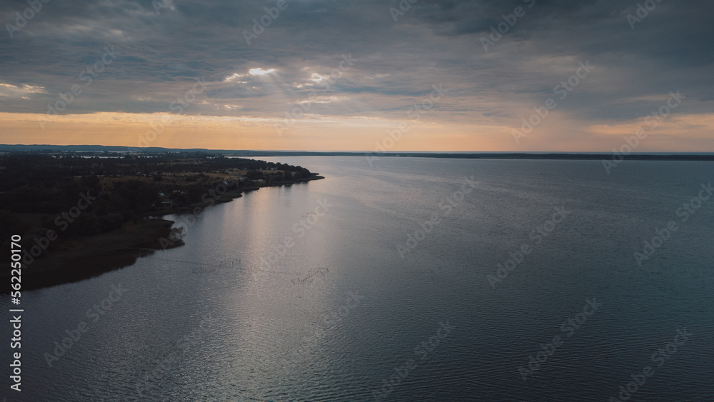 Obraz premium Aerial view of lake with facilities and boats.