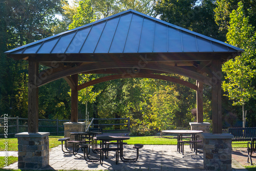 Gazebo or pavilion in a park with some seating and tables providing shade and rest photo