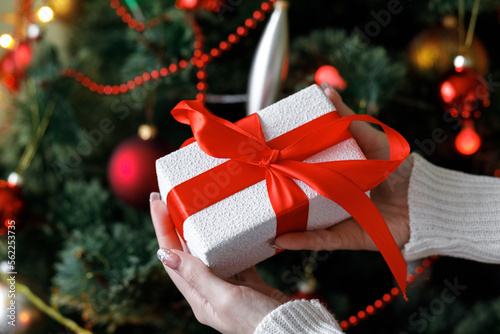 Beautiful gift. New Year's decor. Preparation for the holiday. New Year's gifts on Christmas tree twigs. Christmas tree. Close up.