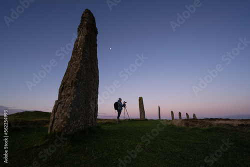 Photographer at Ring of Brodgar standing stones, Orkney, Scotland photo