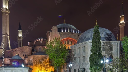 Illuminated Hagia Sophia with flowerbed timelapse - ancient orthodox temple in Istanbul on illuminated at twilight. Aya-Sofia famous landmark of byzantine architecture in Medieval Constantinople photo