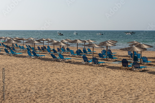 Fototapeta Naklejka Na Ścianę i Meble -  Beach with group of straw umbrellas and beach chairs. Holiday
