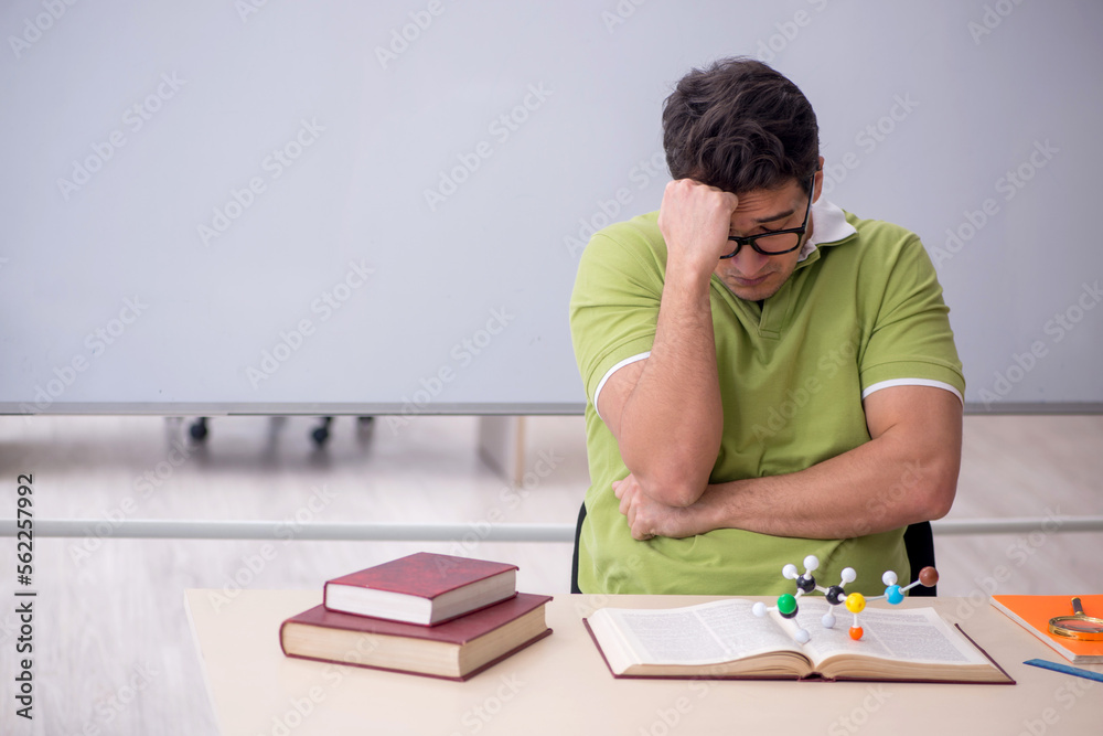 Young male student physicist sitting in the classroom