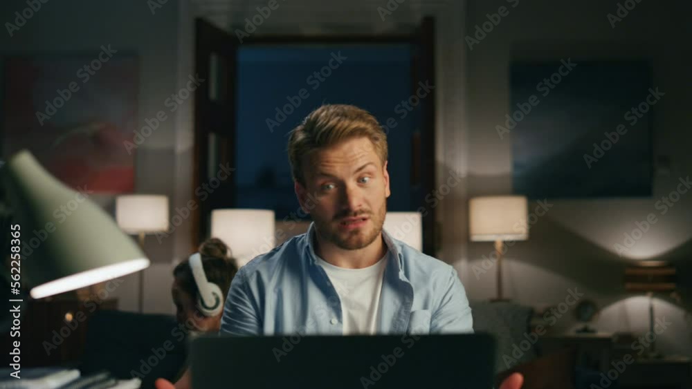 Bearded man talking laptop at night closeup. Guy feeling nervous at workplace Bearded man talking laptop at night closeup. Guy feeling nervous at workplace