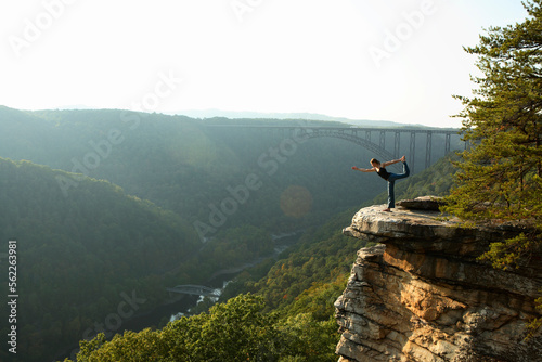 Sarah Chouinard enjoys a late afternoon yoga session (standing bow pose) atop the Bosnian Buttress along the rim of the New Rive photo