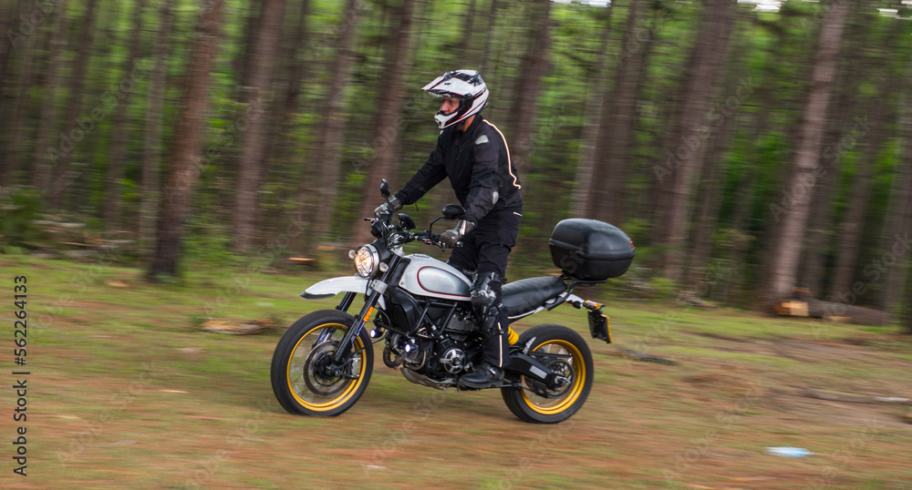 Man riding motorcycle through forest, Nan, Mueang Chiang Rai District, Thailand Man riding motorcycle through forest, Nan, Mueang Chiang Rai District, Thailand