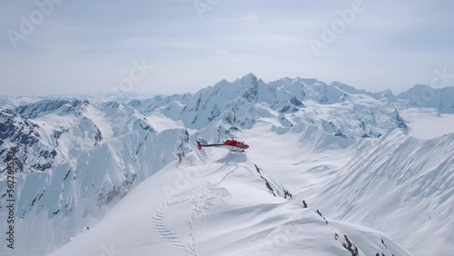 Heli-Skiing helicopter take-off from a snowy mountain in Alaska photo