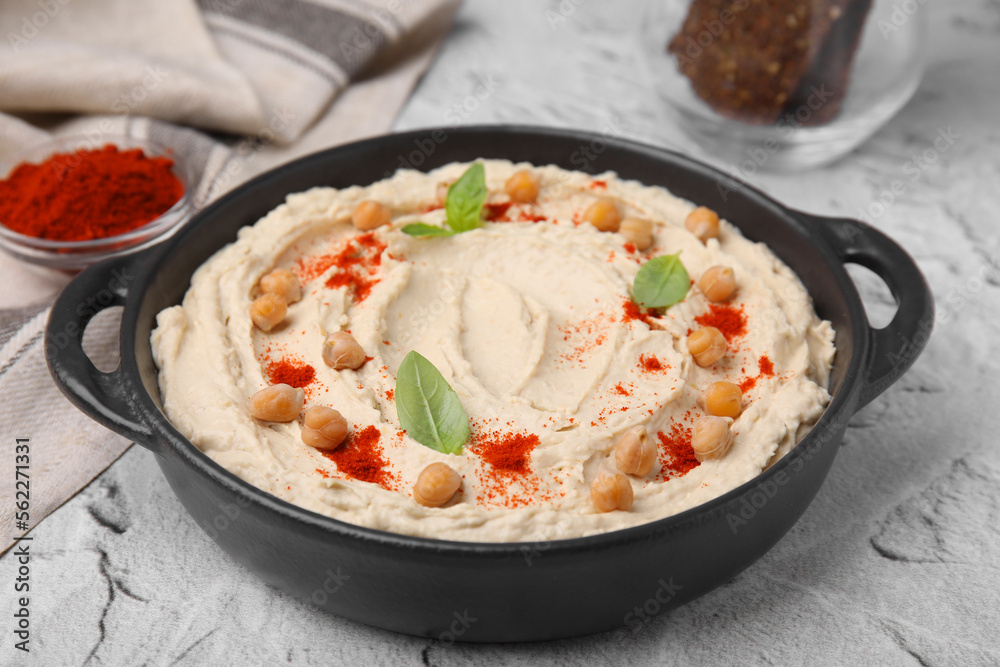 Delicious hummus with chickpeas and paprika served on white textured table, closeup Delicious hummus with chickpeas and paprika served on white textured table, closeup