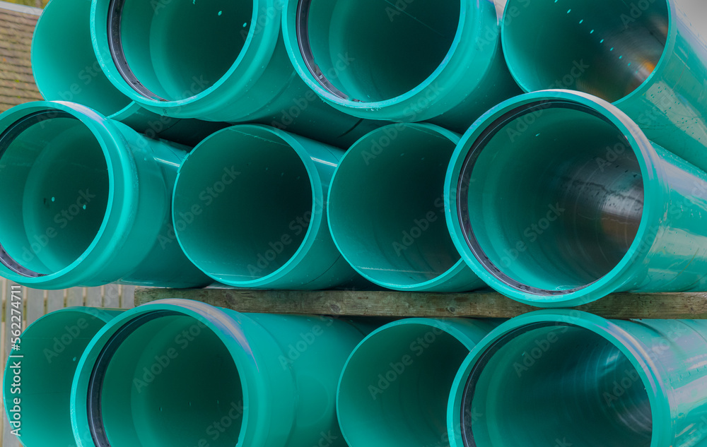 Stacks of green PVC water pipes. PVC water pipes used for construction Stacks of green PVC water pipes. PVC water pipes used for construction
